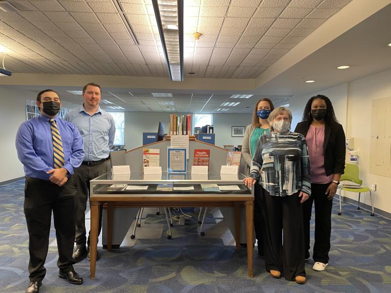 A photo of the Infocus team standing in front of a library display in Reeves.