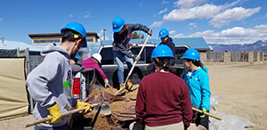 Students shoveling dirt on trip 