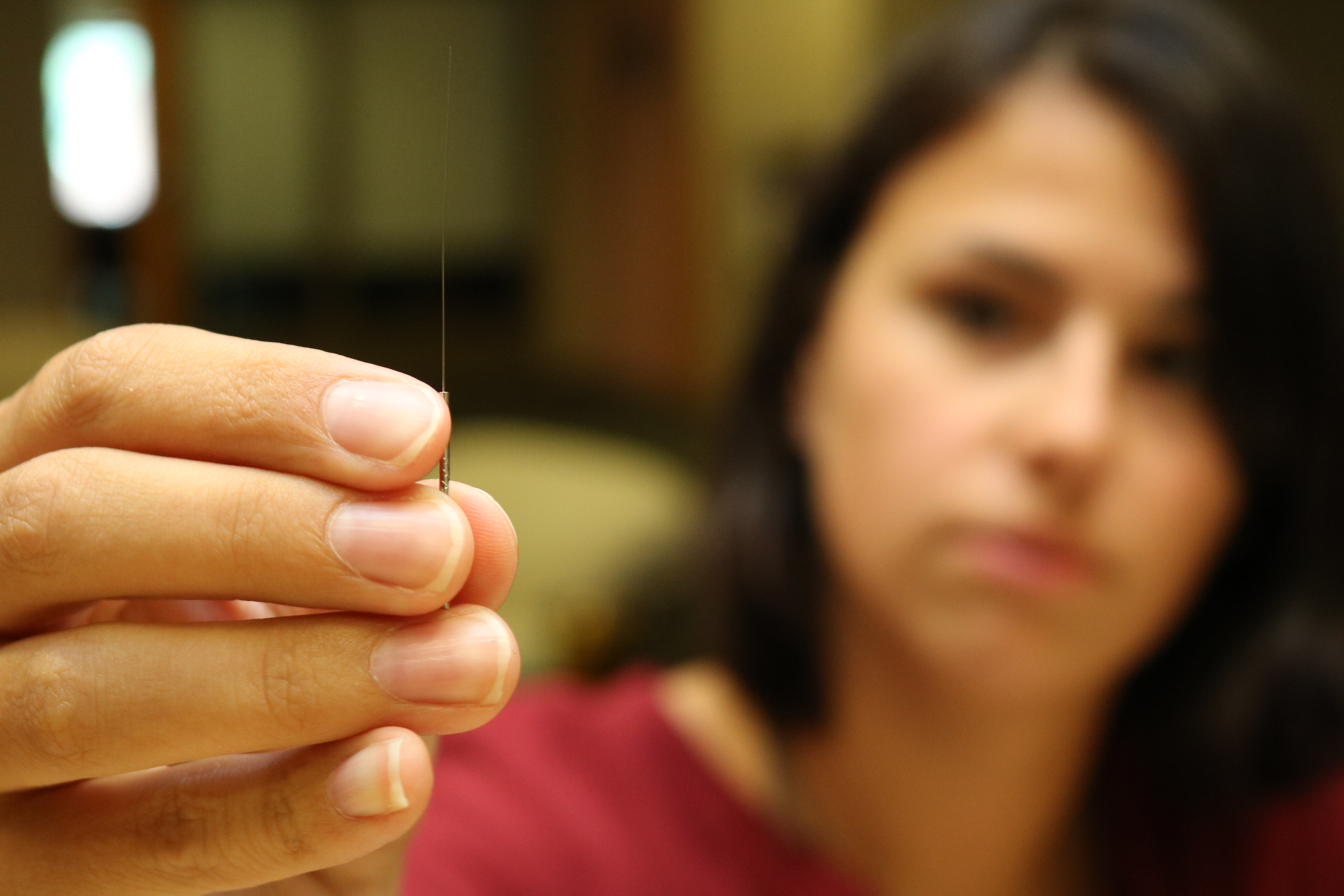 Micaela holding up a needle
