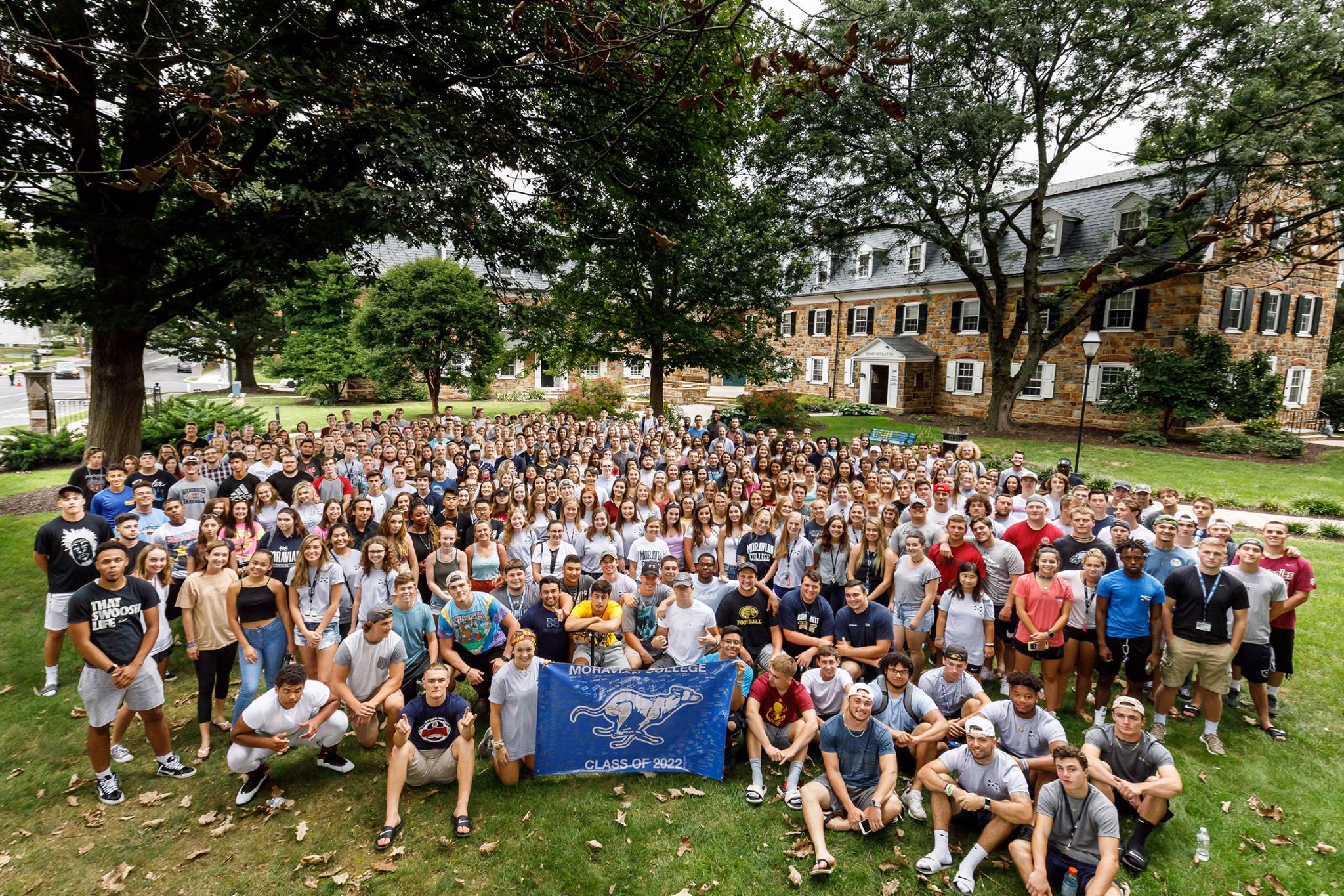 The freshmen class of 2022, which is about 450 students, is seated on the lawn looking up at the camera