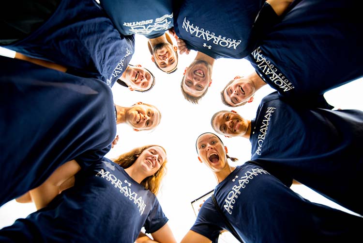 Members of the cross-country team form a circle.