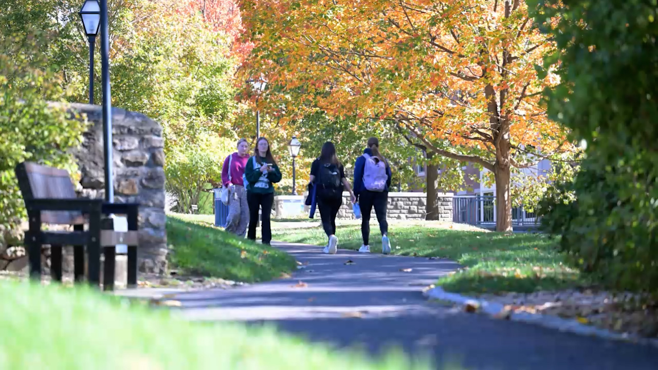 Student walking through campus in the fall