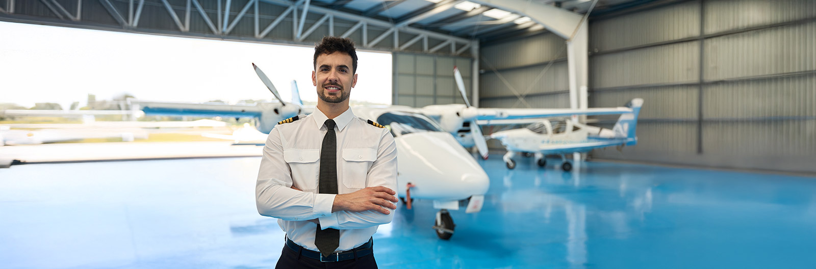 Pilot in front of plane in hanger