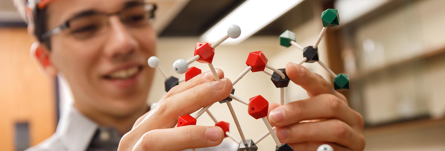 Chemistry student holding a model