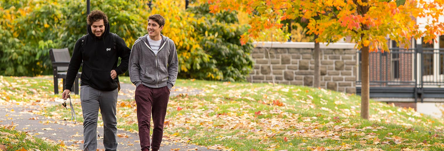 Two students walking on campus in the fall