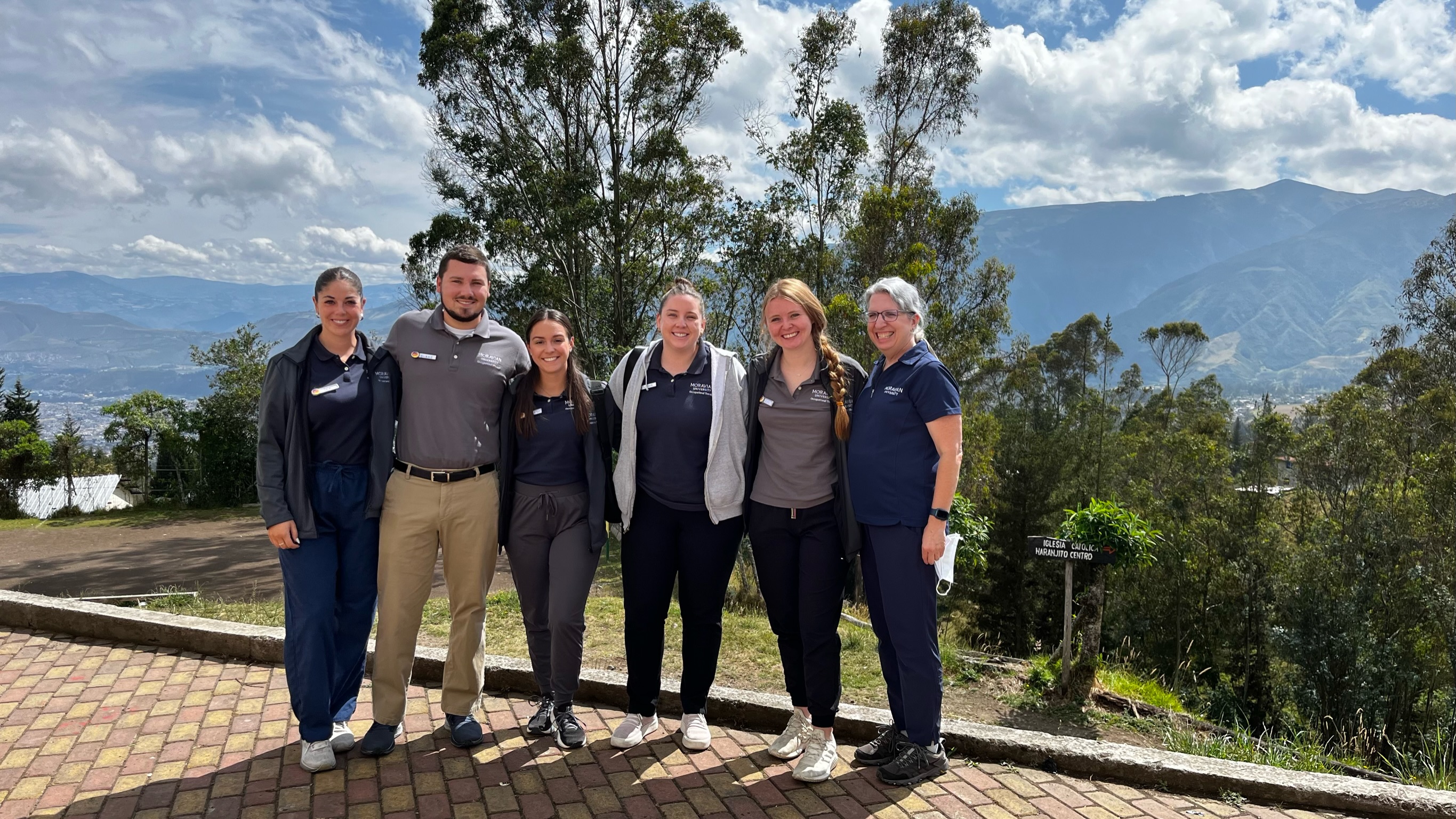 Students on mountaintop in scrubs in Ecuador
