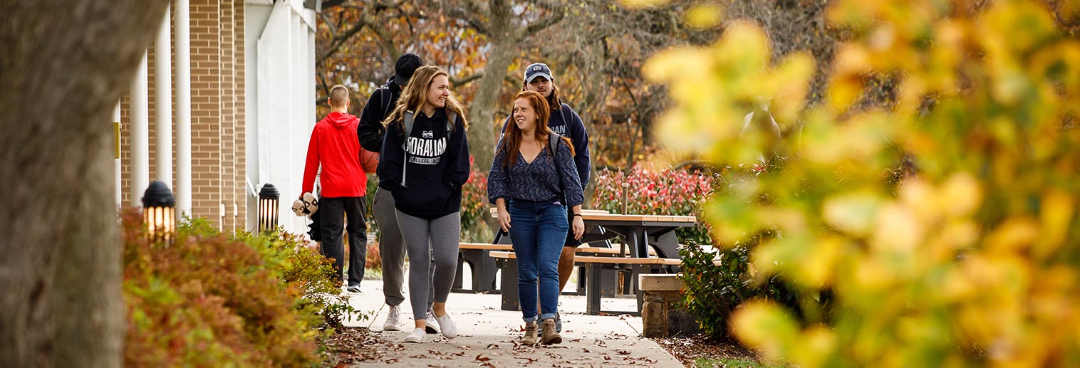 Student walking outside the HUB on fall day