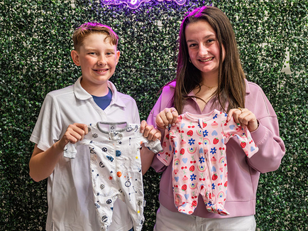 Lily's Hope family holding onesies