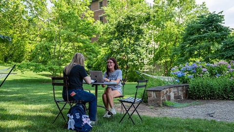 Student sitting outside with laptop