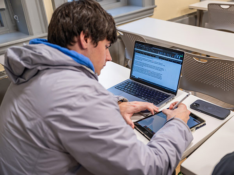 Student using ipad and laptop
