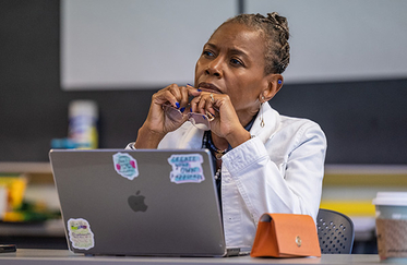 Student sitting in class behind laptop